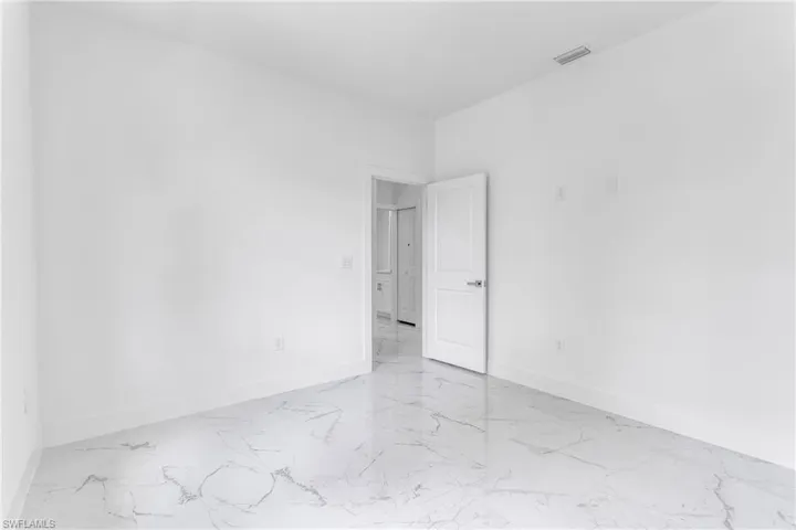 Unfurnished room featuring marble finish floors and baseboards
