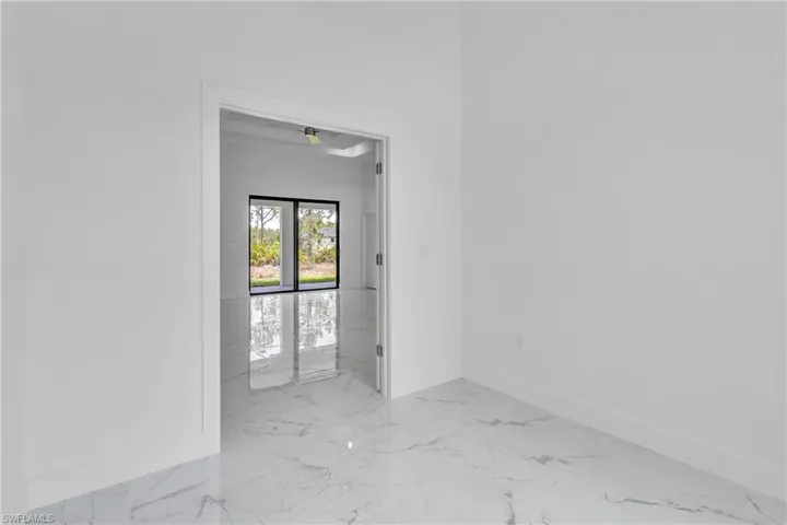 Spare room with marble finish floors and baseboards