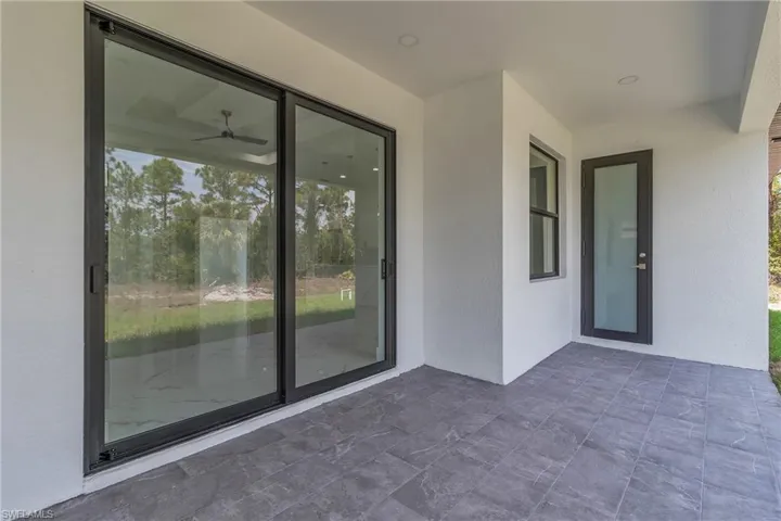 Property entrance featuring stucco siding and a patio