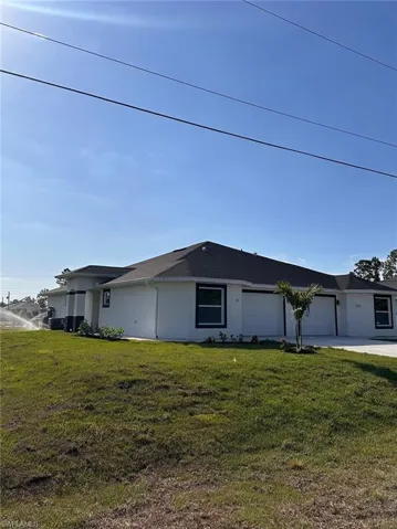 View of side of home with a garage and a yard