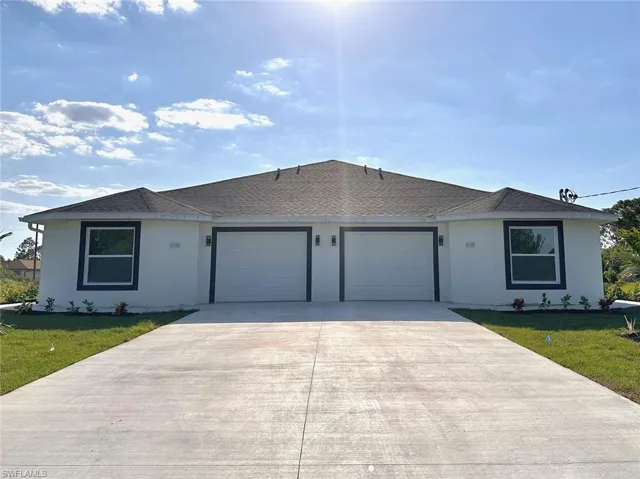 Single story home featuring a garage and a front lawn