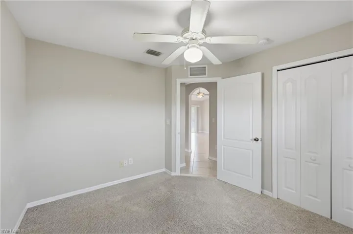Unfurnished bedroom with carpet floors, a closet, and a ceiling fan