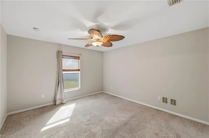 Empty room featuring light carpet and ceiling fan