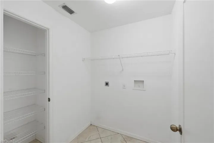 Washroom with washer hookup, electric dryer hookup, and light tile patterned floors