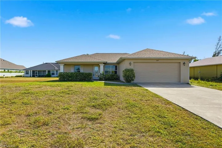 Single story home with stucco siding, a front lawn, driveway, and a garage
