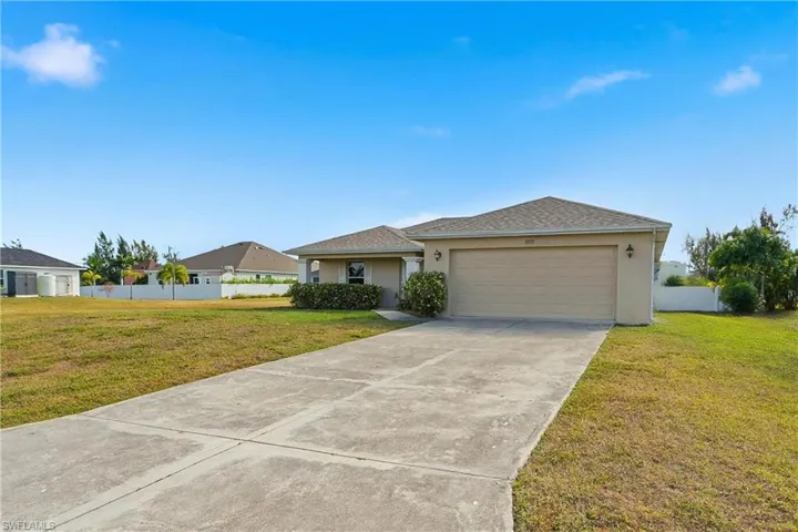 Single story home with stucco siding, driveway, and a garage