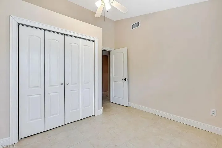 Unfurnished bedroom with a closet, visible vents, and baseboards