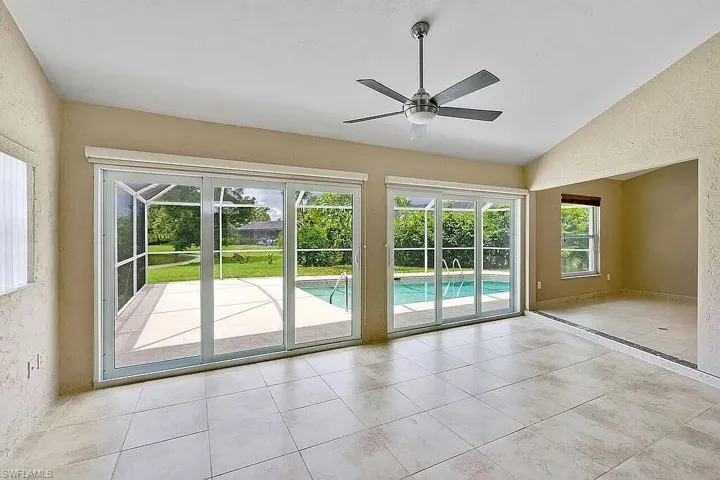 Entryway with a healthy amount of sunlight, a ceiling fan, a textured wall, and lofted ceiling