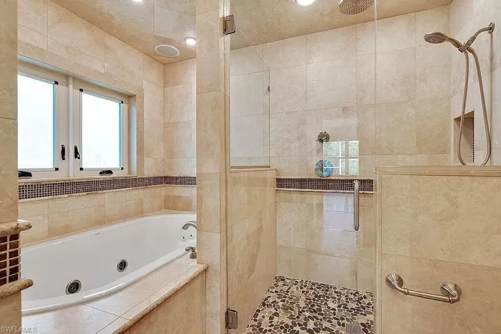 Bathroom featuring a shower stall and a whirlpool tub