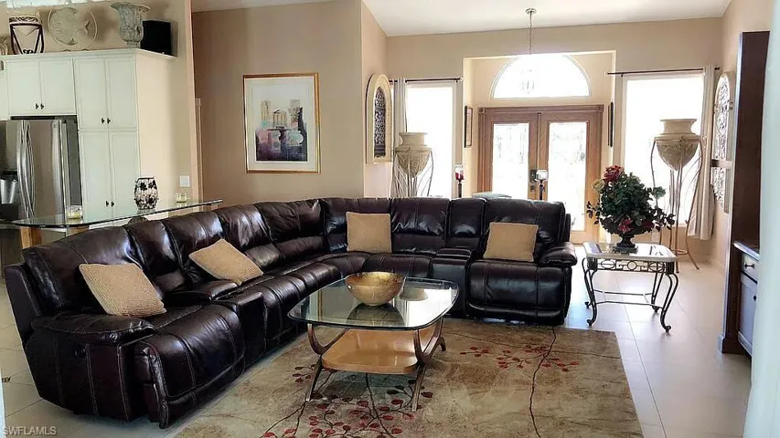Living room with light tile patterned floors and french doors