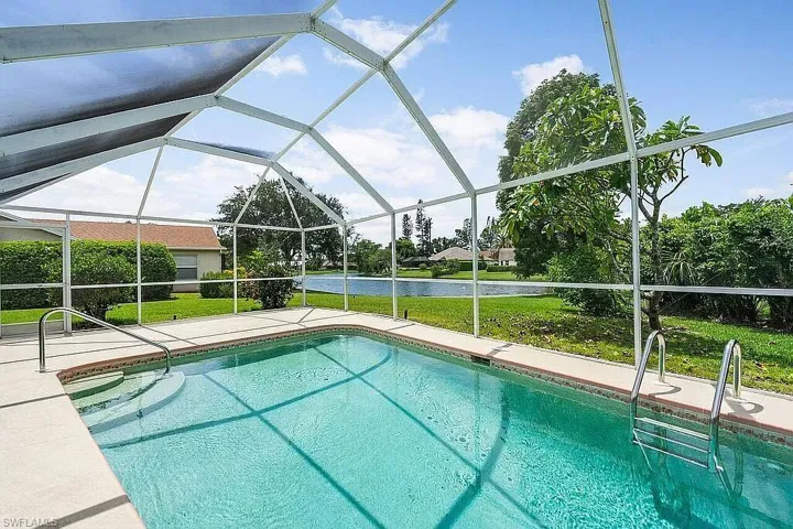 Pool featuring a water view, a patio, a yard, and a lanai