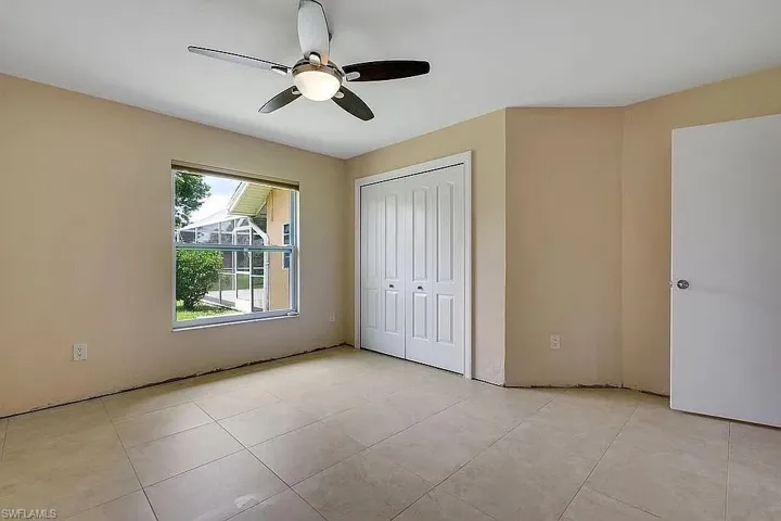 Unfurnished bedroom featuring a closet, a ceiling fan, and light tile patterned flooring
