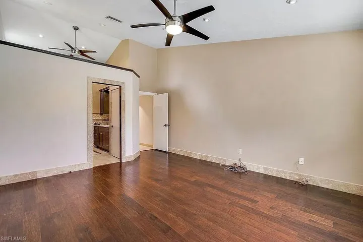 Spare room with high vaulted ceiling, a ceiling fan, recessed lighting, wood finished floors, and baseboards