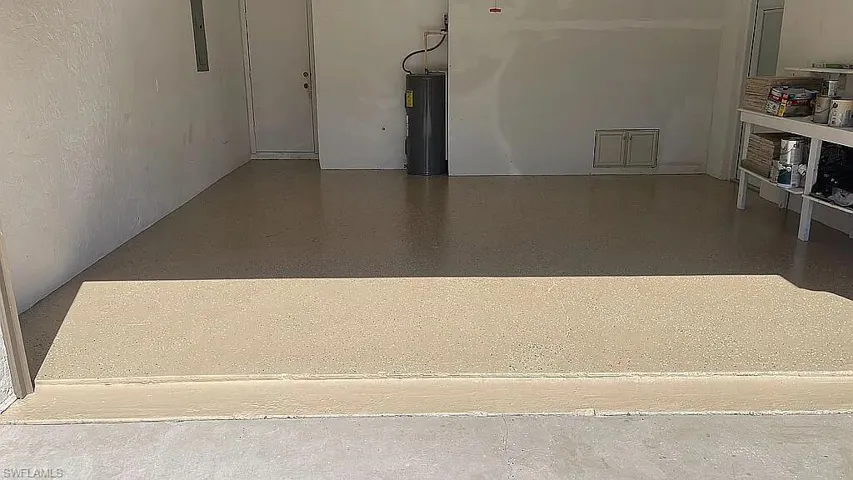 Garage featuring electric panel and water heater