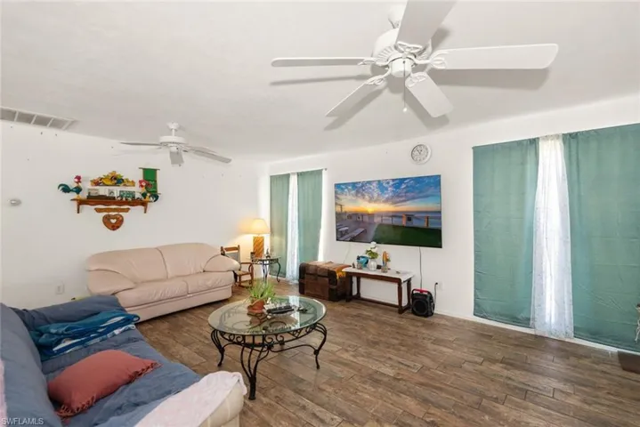 Living room with dark wood finished floors and ceiling fan