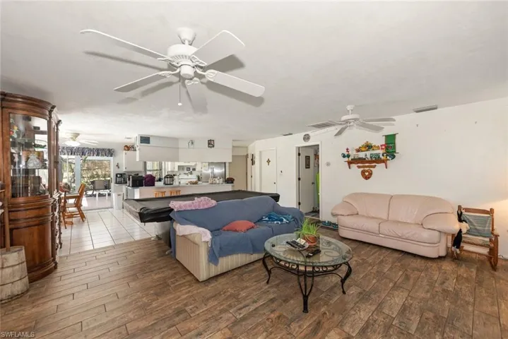 Living room with a ceiling fan and dark wood finished floors