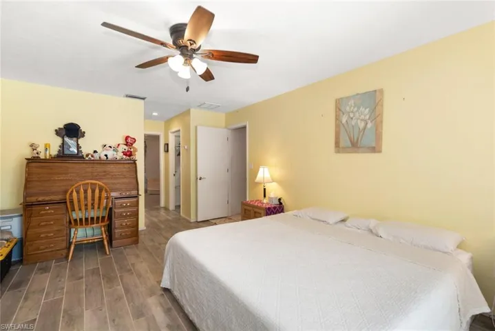 Bedroom with wood tiled floors and a ceiling fan