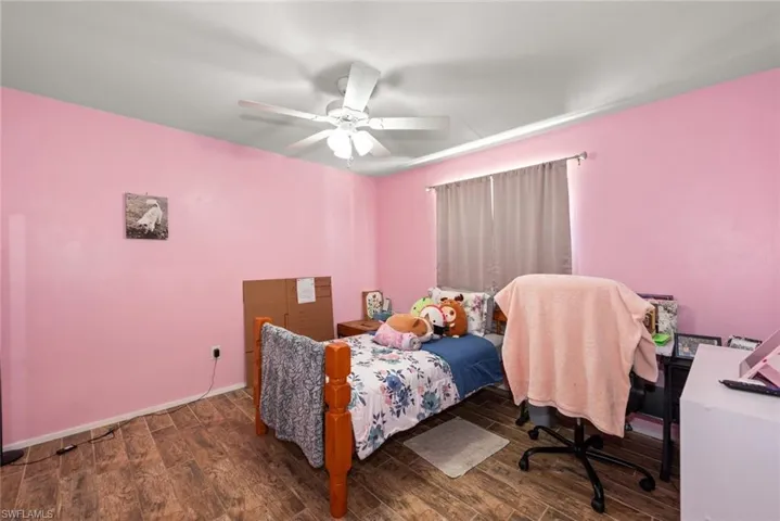 Bedroom featuring dark wood-style flooring and ceiling fan