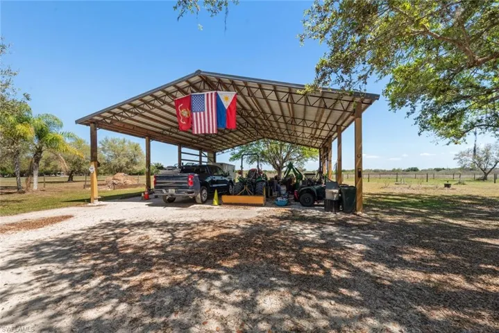 View of parking featuring a detached carport and driveway