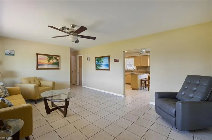 Living room with ceiling fan, sink, and light tile patterned floors
