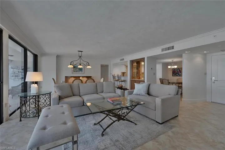 Living area with hanging lights and ornamental molding