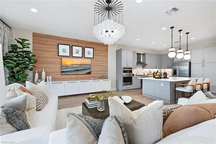 Living room featuring sink, a chandelier, and light hardwood / wood-style floors