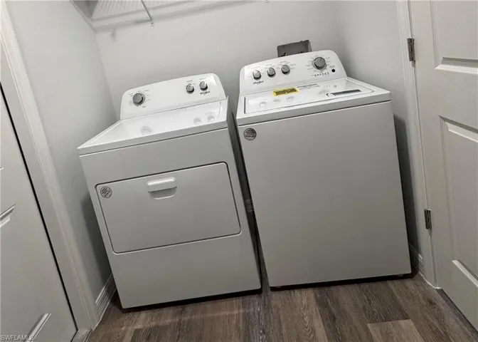 Laundry area with washing machine and clothes dryer and dark wood-style flooring