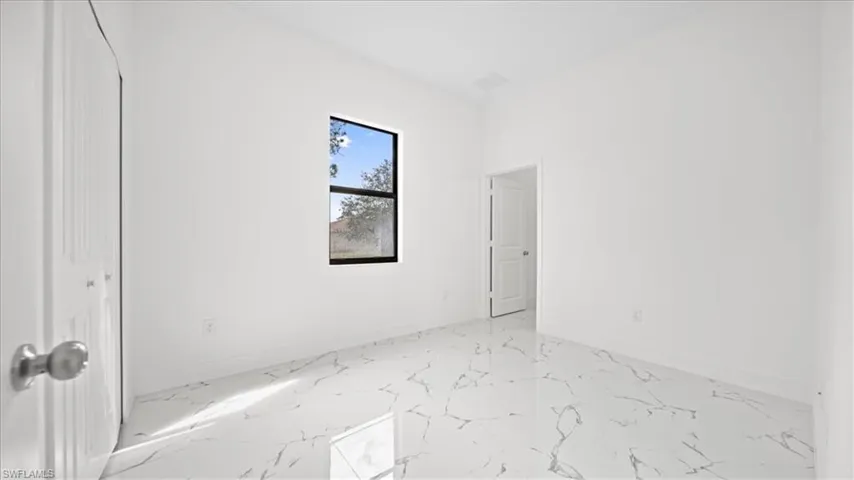 Unfurnished bedroom featuring a closet and light marble finish flooring