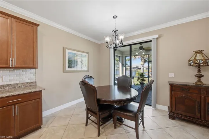 Dining area featuring a chandelier, ornamental molding, a ceiling fan, and light tile patterned floors