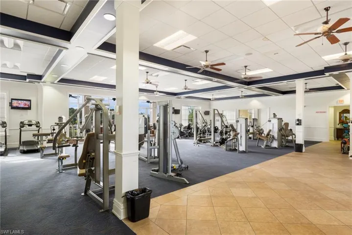 Workout area featuring coffered ceiling, a ceiling fan, and a paneled ceiling