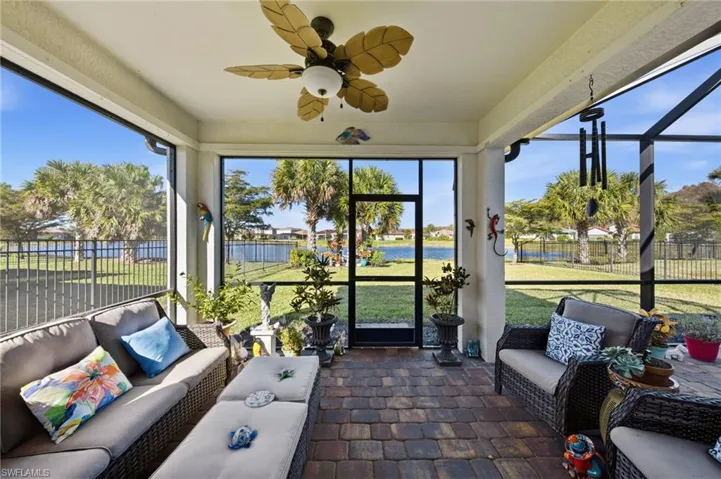 Sunroom / solarium with outdoor seating, a ceiling fan, and a water view