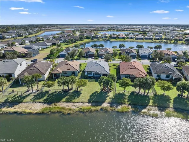 Aerial view of property and surrounding area featuring a nearby body of water and nearby suburban area