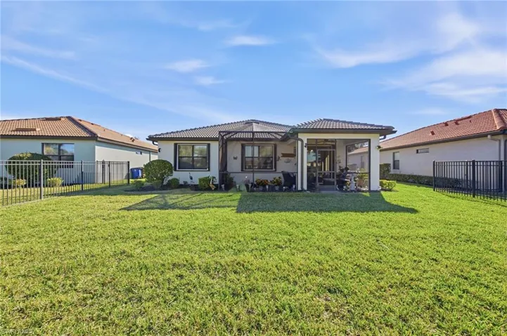 Back of property featuring a fenced backyard, a patio area, a tile roof, and stucco siding