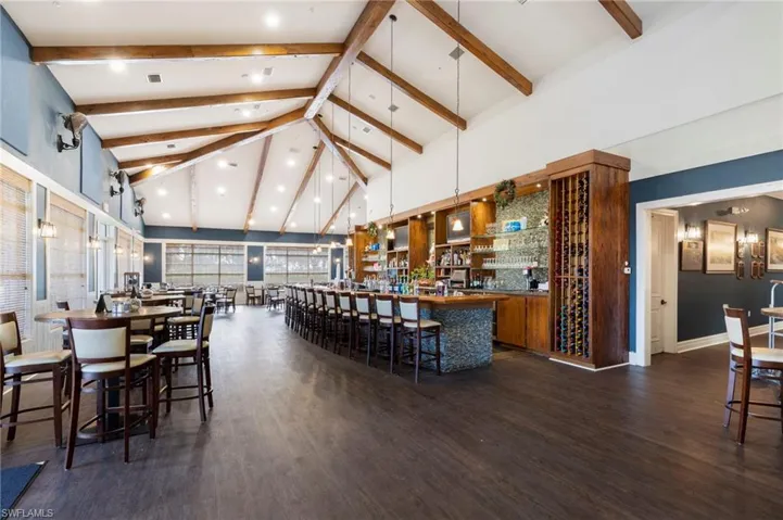 Community bar area featuring dark countertops, lofted ceiling, hanging light fixtures, and open shelves