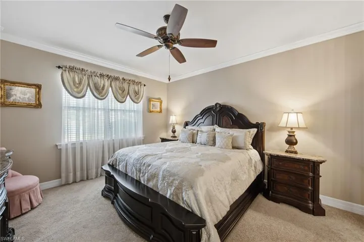 Bedroom with crown molding, light carpet, and ceiling fan