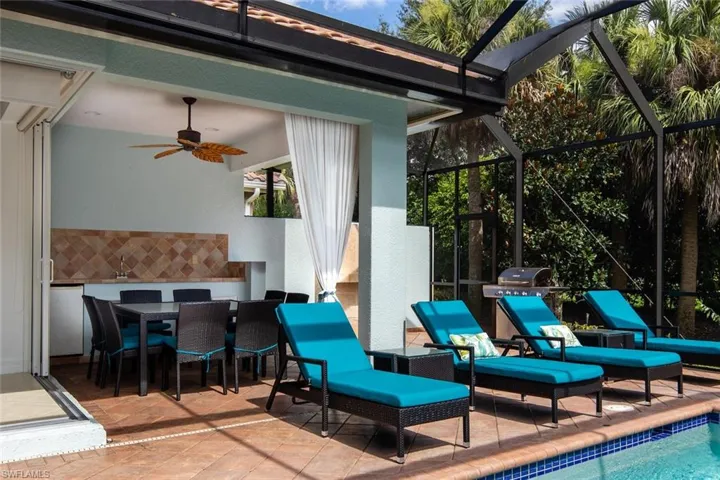 View of patio with outdoor dining space, a sunroom, glass enclosure, and an outdoor pool