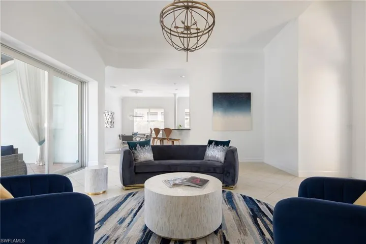 Tiled living area with a chandelier and crown molding