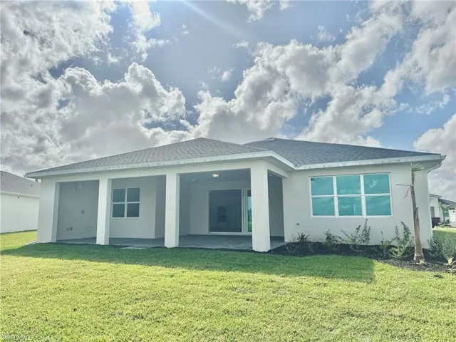 Backyard view with spacious covered lanai featuring pre-plumbing for outdoor kitchen, 12 foot sliding glass doors and exterior full height privacy wall