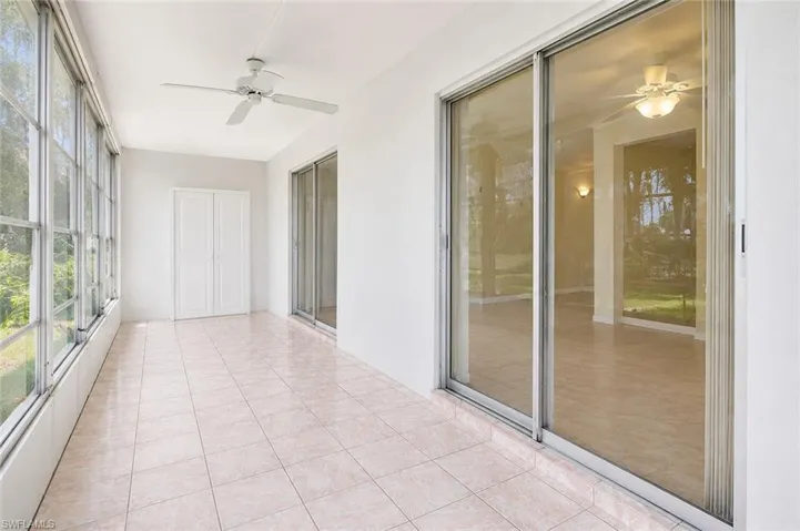Enclosed patio featuring light-toned tile flooring, white walls, and a ceiling fan