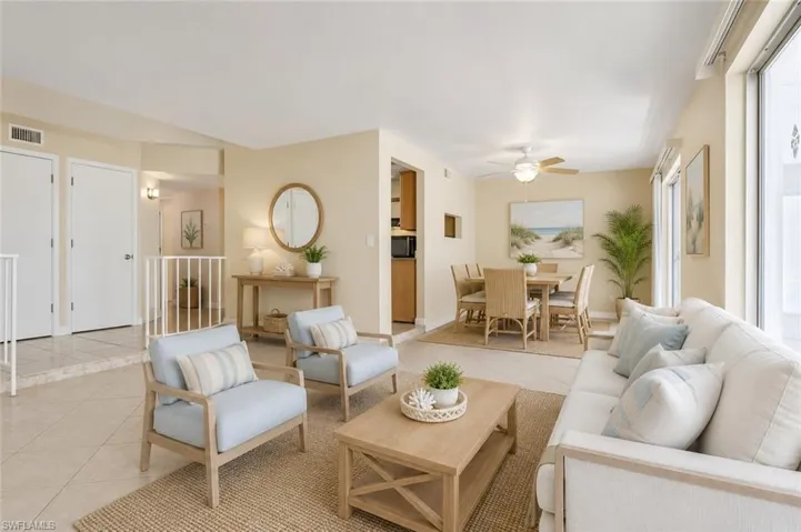 Open-concept living area with tile flooring and abundant natural light from large windows