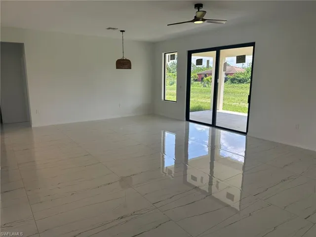 Unfurnished room with ceiling fan and light tile patterned floors