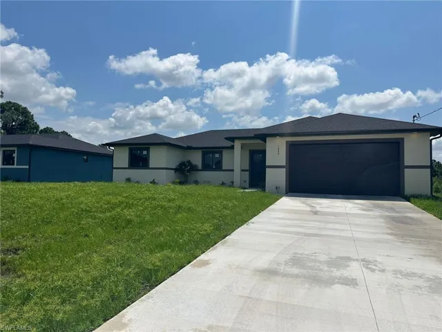 View of front of property featuring a garage and a front yard