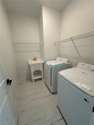 Laundry area featuring washing machine and dryer and light tile patterned floors