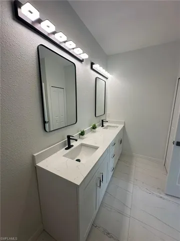Bathroom with tile patterned floors and dual bowl vanity