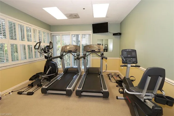 Gym with carpet and a paneled ceiling