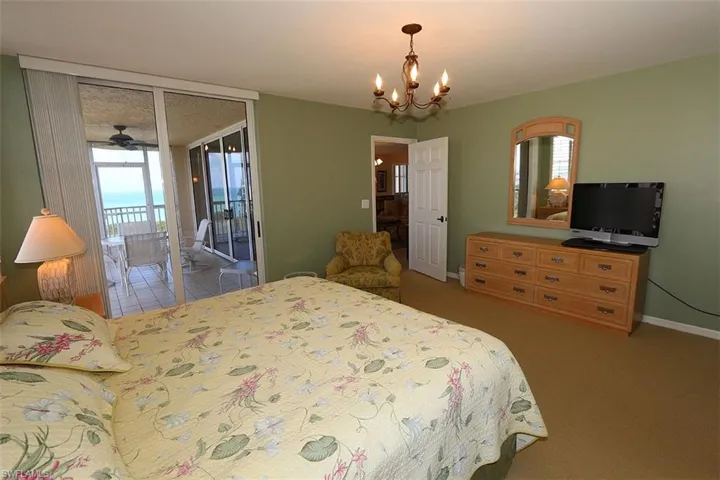 Bedroom with access to outside, a chandelier, and carpet floors