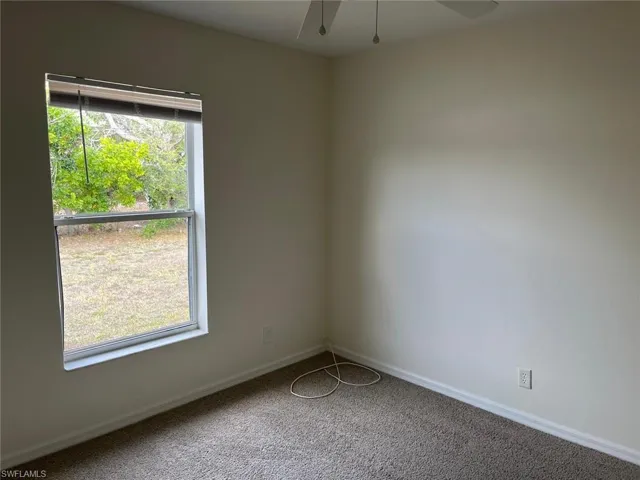Unfurnished room featuring light colored carpet and a ceiling fan