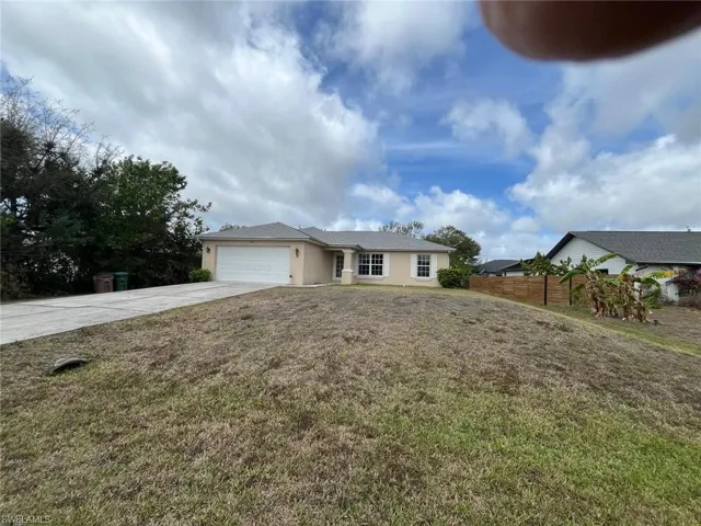 Single story home with an attached garage, stucco siding, and driveway