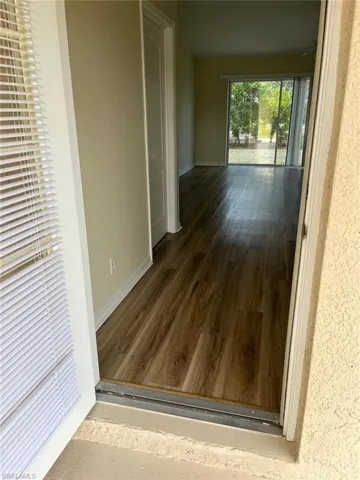 Corridor with baseboards and dark wood-style floors