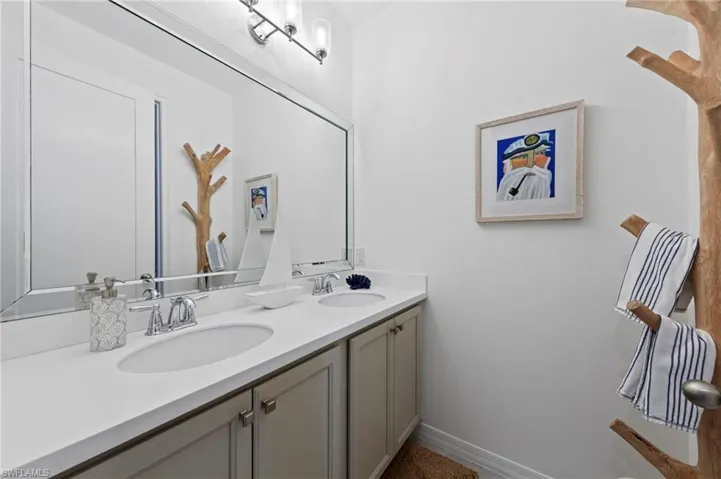 Hall bath features a dual sink vanity and separate tiled tub/shower with FRAMELESS GLASS ENCLOSURE in a separate room for multiple guests. New added CAN LIGHTING (September 2023), new FRAMELESS GLASS SHOWER DOOR (February 2022), new BEVELED MIRROR (February 2022)